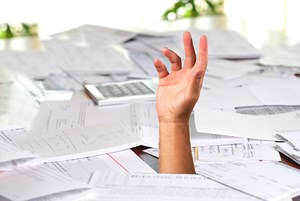 Hand drowning in paper bills image