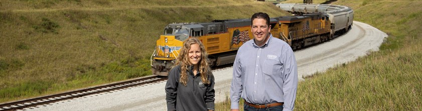 Economic development team member with business partner standing in front of train