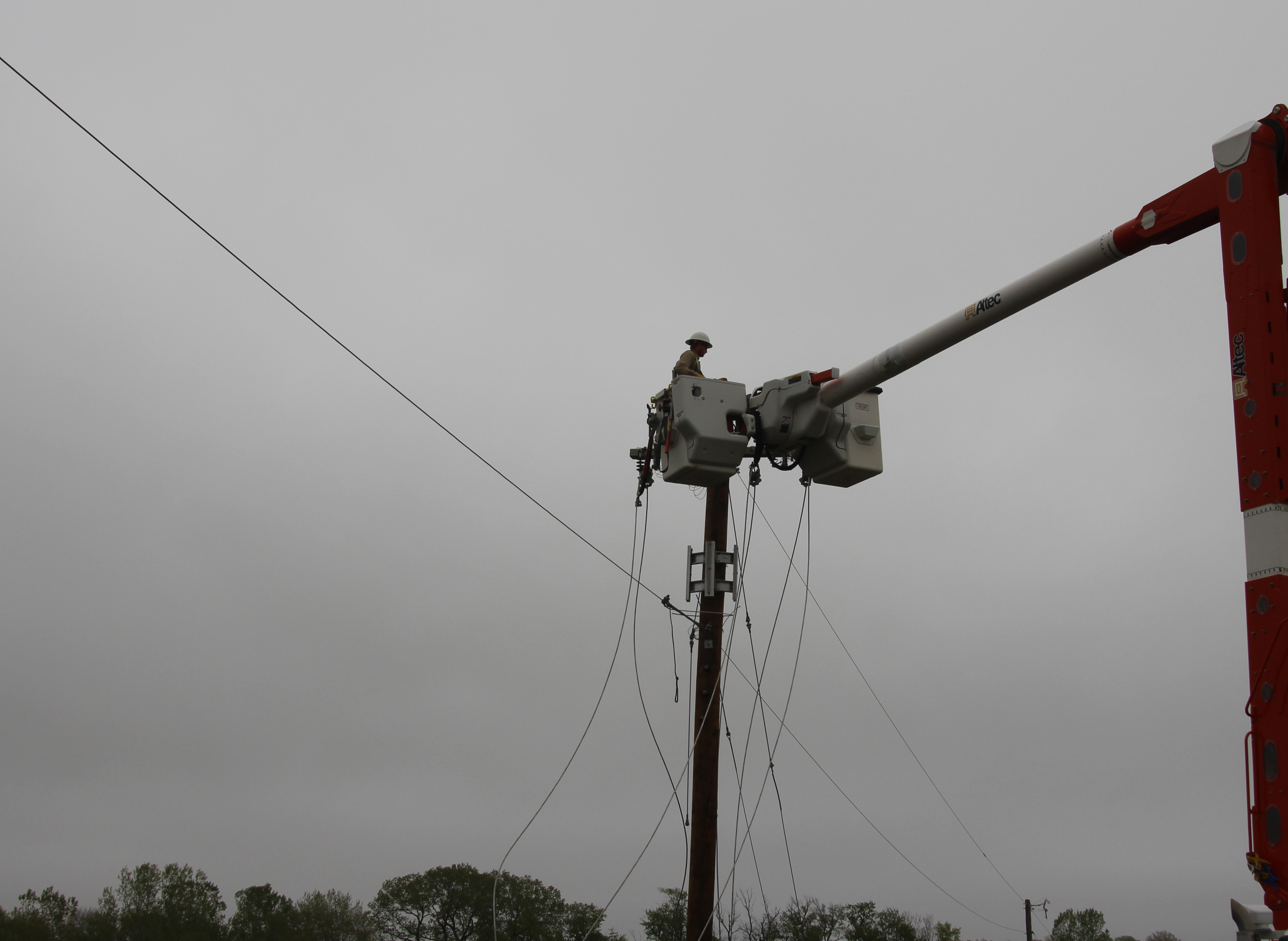 OPPD employee in bucket repairing lines on pole